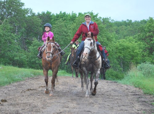 A young rider was led on the trail enjoying every minute spent with her horse.