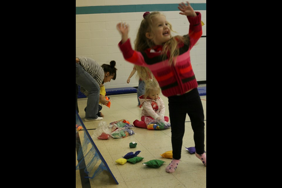 A child celebrates a bean bag toss victory at the Day of Impact.