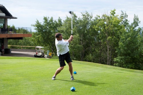 Marten Wright tees up off of the first hole, driving the ball far along the fairway.