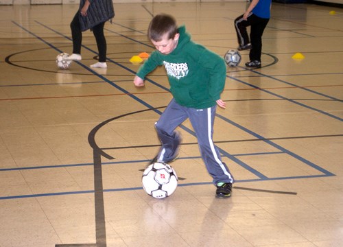 This soccer enthusiast practices his skills as he spins around the soccer ball.