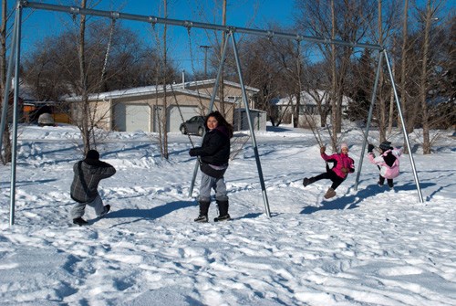Youth enjoy the swings at the school playground.