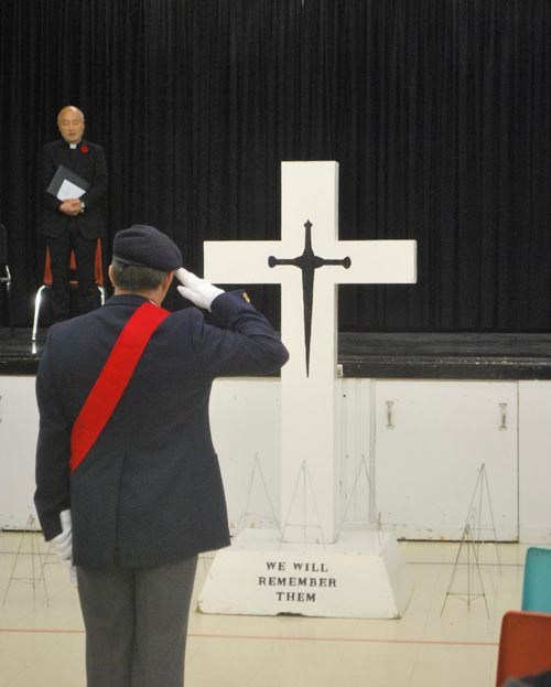 The Sergeant at Arms, John Voutour, salutes the cross representing all soldiers lost.