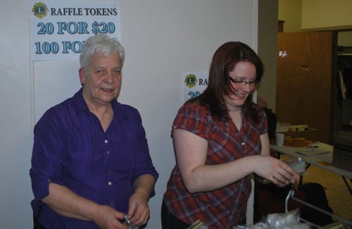 Myrla Holland (left) and Janellle Wilson hand out tickets for the raffle items at the 21st annual Carlyle Lions dinner and auction fundraiser. It was a record-breaking year for the group, raising more than $37,000 at the event.