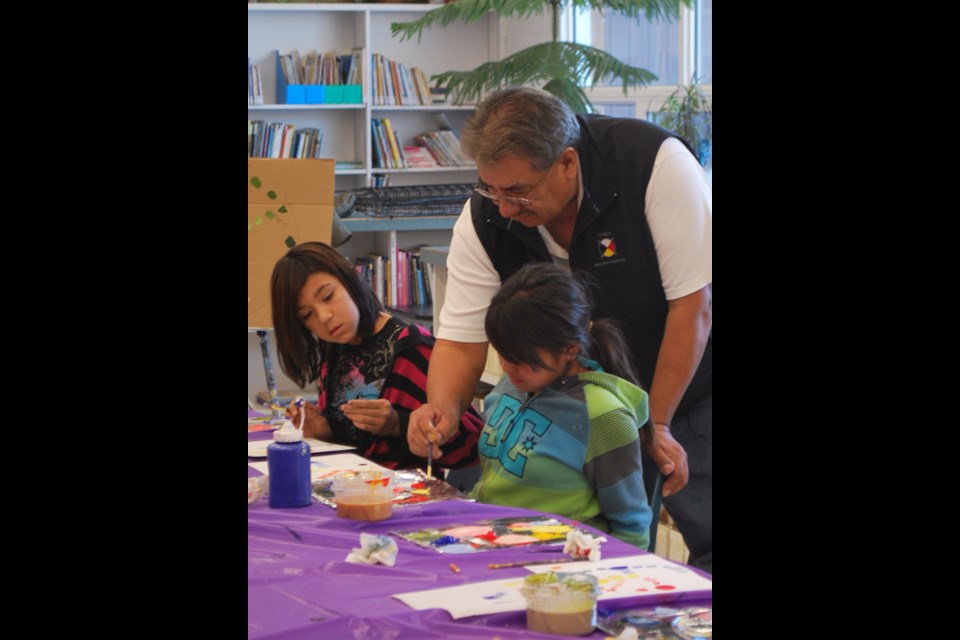 Michael Lonechild spent almost two weeks with the Grade 5/6 class at Carlyle Elementary School passing on his painting knowledge. Pictured here are Jylissa Lonechild (left), Michael Lonechild (center) and Shanika Allary (right).