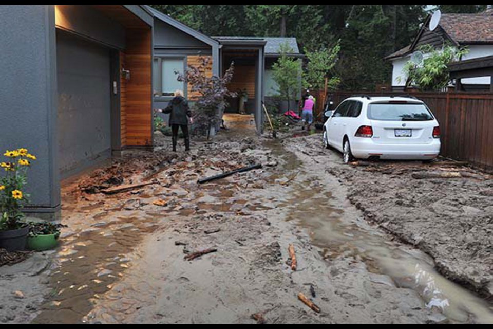 Floodwaters cover Fromme Road with rocks, water, and other debris in Lynn Valley in North Vancouver on Tuesday.