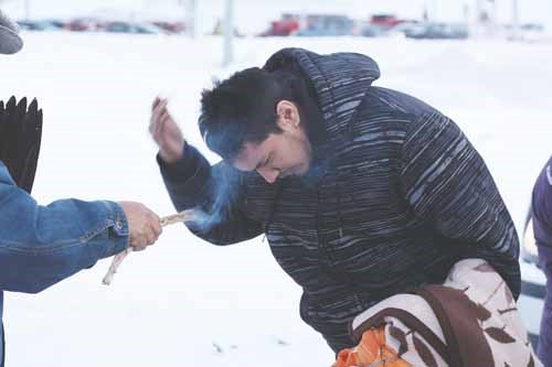 Despite bitter temperatures and biting winds Friday afternoon, dozens turned out for the latest Idle No More rally including this member of the Buffalo Lodge Singers who prepares for the protest by being blessed with guidance and protection with sweetgrass and prayers. The group, aided by RCMP officers who blocked side roads and the westbound lane of Broadway Street, marched from the Howard Johnson Hotel to the Yorkton Tribal Council offices on Fifth Avenue.
