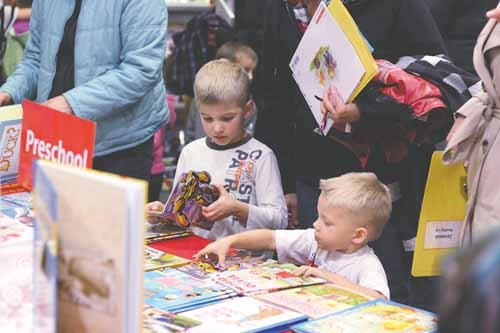 Brothers Alex, 5, and Rylan, 3, Varga peruse books at the MC Knoll School Community Council (SCC) Book Fair during Education Week on Oct 17. Last year the SCC used their fundraising monies for new playground equipment.