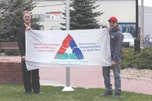 Yorkton Mayor James Wilson and EMW Industrial assistant manager of environment, health, and safety Dustin Eskra raised a flag for North American Occupational Safety and Health (NAOSH) Week outside City Hall last Wednesday. NAOSH Week was May 6 through 12.