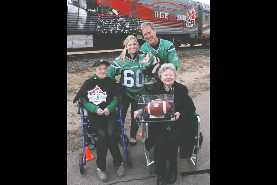 Celebrations for the 100th instalment of the Canadian Football League championship came to Yorkton last Tuesday afternoon as football fanatics, both young and old, got together for some football, food and fun. Back (L-R): Carley Smith, communications representative for the CFL and James Wilson, Yorkton mayor, holding &#8220;Alouette II&#8221; in honour of a ceremony in 1954 when then-Mayor C.G. Langrill presented the champion Edmonton Eskimos with a pig, &#8220;Alouette,&#8221; for &#8220;bringing home the bacon.&#8221; Front, Lydia Zimmer, a 104-year-old fan of the Saskatchewan Roughriders and Wilma Wilkinson, daughter of Langrill. See related story.