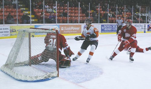 Yorkton Terriers Jeremy Johnson scores high over Weyburn Red Wing goaltender Brett Teskey&#8217;s glove hand in the season opener for the local Saskatchewan Junior Hockey League franchise Friday at the Farrell Agencies Arena.