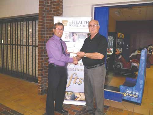 Ukrainian Catholic Brotherhood President Peter Moroz with a cheque for $1500.