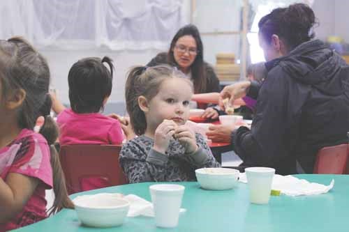 Emily Cheverie-Dares enjoys a free sandwich with her kindergarten classmates and their families during Dr. Brass School&#8217;s &#8220;Welcome Back Lunch&#8221; on September 13. The event is an opportunity for families and community supporters--such as the Rotary Readers, who read to the small children, and the Lion&#8217;s Club members, who support the school&#8217;s breakfast program--to see the classrooms, meet the teachers and build fellowship within the school setting, said Dianna Kozak, the community school coordinator.