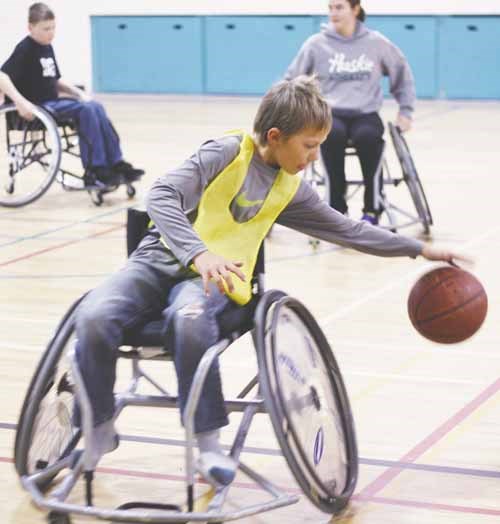 Mobility-impaired and able-bodied kids and occupational therapists from the Good Spirit School Division play wheelchair basketball November 15 at Gloria Hayden Community Centre. See Page A14 for related story.