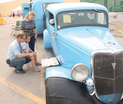 Big Brothers Big Sisters 12th Annual Show &#8216;n&#8217; Shine was held Saturday in the Wal-Mart parking lot in Yorkton. The event attracted a range of makes and models of automobiles. The day also had scheduled Tire Changing Competition, Tire Rolling Contest, raffles and draws, face painting for all ages, and a hamburger and hot dog sale. All proceeds was planned to go to Big Brothers Big Sisters of Yorkton, with Walmart matching up to $2,000. Here Cary, Mike and Tishen Eburne of Churchbridge check out a map showing where the vintage car and trailer have traveled across North America.