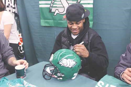The 2013 Grey Cup MVP Kory Sheets signs a Riders football helmet for a lucky fan during the Riders autograph session held at the Yorkton Co-op Food Store on Friday, Jan. 17. See related story under Local Sports.