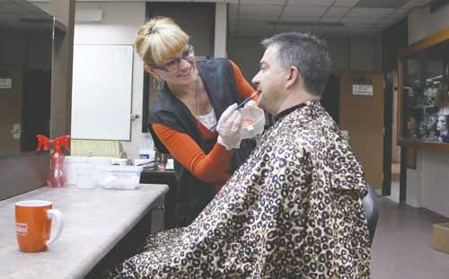 YRHS cosmetology teacher Carmella Lutz dyes principal Mike Haczkewicz&#8217;s Movember &#8216;stache Raiders orange to celebrate the last day of the month-long campaign to raise awareness of and money for men&#8217;s cancer issues.