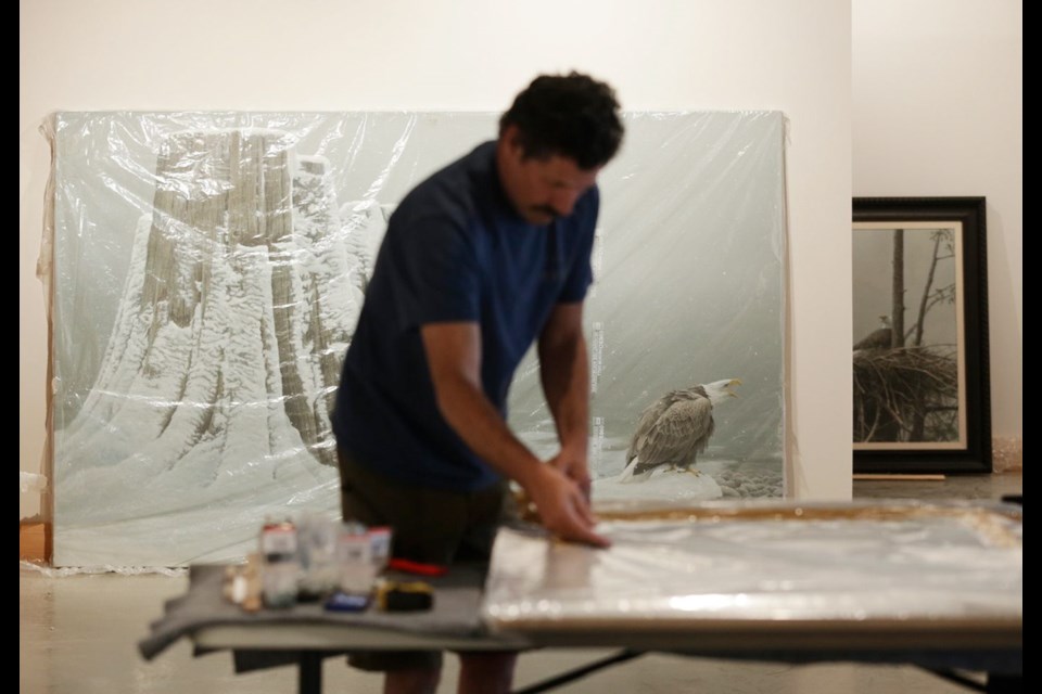 Master framer, Steve Jarman, works on a Robert Bateman piece at the Bateman Centre in the CPR Steamship Terminal building.