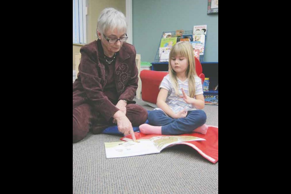 Melody Wood reads the brightly illustrated book, The Wind Blew by Pat Hutchins to five-year-old Kahlan Stromberg at the Yorkton Public Library during Family Literacy Day, Friday, January 25.