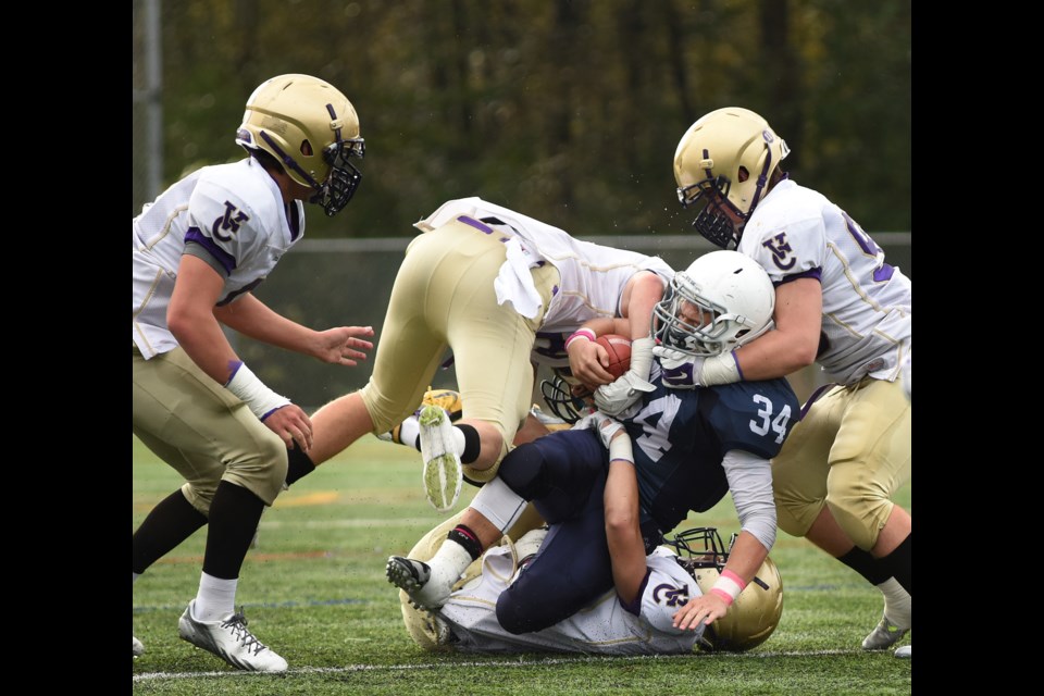 Notre Dame running back Nicholas Carusi (No. 34) is hauled down by three Vancouver College tacklers in a 46-7 Vancouver College win at Burnaby Lake Park on Oct. 31. Photo Dan Toulgoet