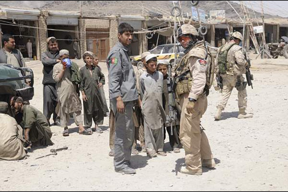 Burnaby RCMP Cpl. Gregor Aitken, in the military fatigues, served in the Canadian Armed Forces from 1993 to ‘97. He is seen here in Afghanistan during a volunteer mission in 2009 with the RCMP. Officers were sent overseas to train local police.