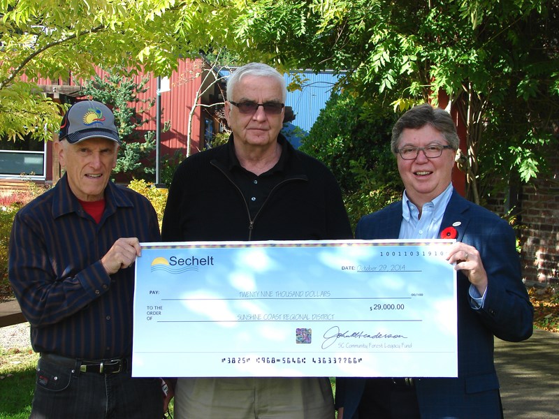 Sunshine Coast Regional District board chair Garry Nohr (centre) accepts a cheque for $29,000 from Tom Pinfold (left), Sunshine Coast community forest legacy fund assessment committee, and Sechelt Mayor John Henderson.