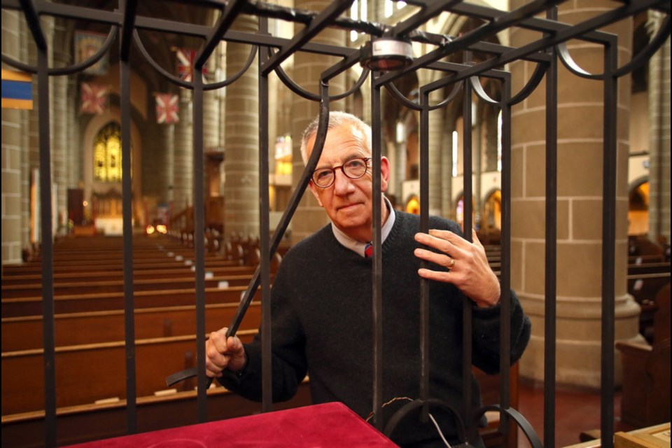 Monday: Rev. Logan McMenamie with the cut bar on the display case that has been broken into at Christ Church Cathedral.