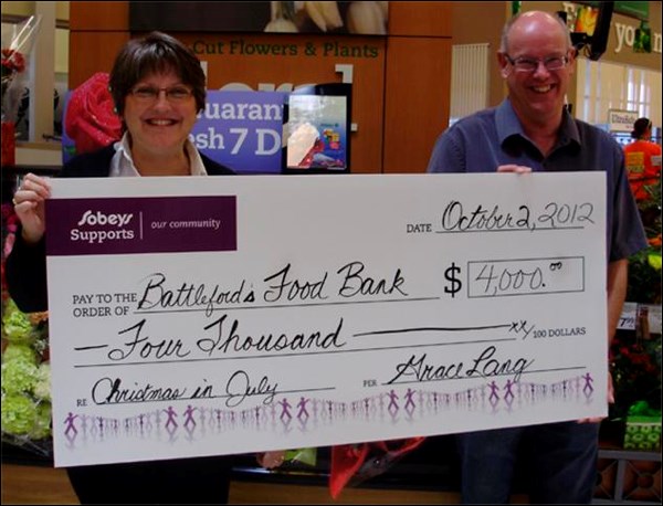 Sobey&#8217;s gave a large donation to the Battlefords and District Food Bank Oct. 2, as part of their &#8220;Christmas in July&#8221; fundraiser. For the fundraiser, patrons had the option of buying paper soup pots to put on the wall, and a total of $3,200 was raised this way. About $1,000 of this was raised single-handedly, by 15-year-old Marizella Salag. 
The $3,200 raised was the fourth-largest amount for a Sobey&#8217;s of its size in the country, which led Sobey&#8217;s Canada to contribute an additional $750. Sobey&#8217;s regularly donates its bakery items to the food bank, and hopes to turn its &#8220;Christmas in July&#8221; fundraiser into a regular event. Sobeys' Grace Lang makes the presentation to Food Bank Executive Director Bill Hall.