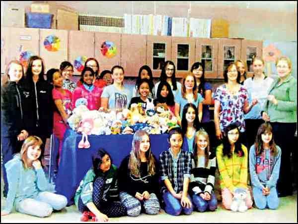 The summer is over and students are returning to the classrooms, books and tests. Students at Holy Family are also returning to their Stewardship Club, which raises funds to support social justice organizations here and around the world. The club, which is led by teachers Karen Walliser, Carol Zurevinski and Liz Spriggs, is in its third year. The club raised $200 by selling rosaries the students and teachers made. Cheques were presented in June to Habitat for Humanity and Interval House
Interval House representative Sandy Tarnowsky accepts a cheque from Holy Family Stewardship Club and teacher, Carol Zurevinski.