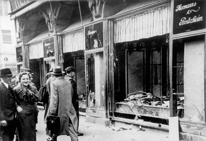 Crowds survey damage done to Jewish shops in Germany following the Kristallnacht pogrom in November 1938. A man (bottom) examines damage to a leather goods shop in Berlin. Photos German Federal Archive
