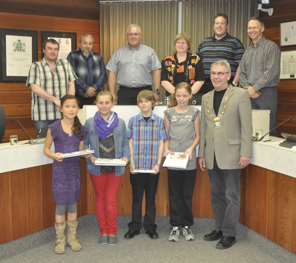 It was a night of poetry at North Battleford city council Monday. Four Grade 5 students from Bready Elementary School read poems at the start of the meeting as part of the Mayor&#8217;s Poetry City Challenge. In honour of April being Poetry Month, Mayor Michael Fougere of Regina had issued the poetry challenge to cities across the country, and North Battleford took up the cause. The four poems the students had written and presented all had a theme celebrating the centennial of the city. In recognition, Mayor Ian Hamilton presented each of the children with the book, Reflections of North Battleford. Seen in the photo are (front row) Ashlyn Elmer (Celebrating a Century), Alex Chmelnyk (The Timeline), Tanner Gartner (What is My City?), Catherine Zens (A Long Time Ago, A Hundred Years Ago) and mayor Ian Hamilton; (back row) councillors Trent Houk, Ray Fox, Greg Lightfoot, Cathy Richardson, Ryan Bater and Don Buglas.