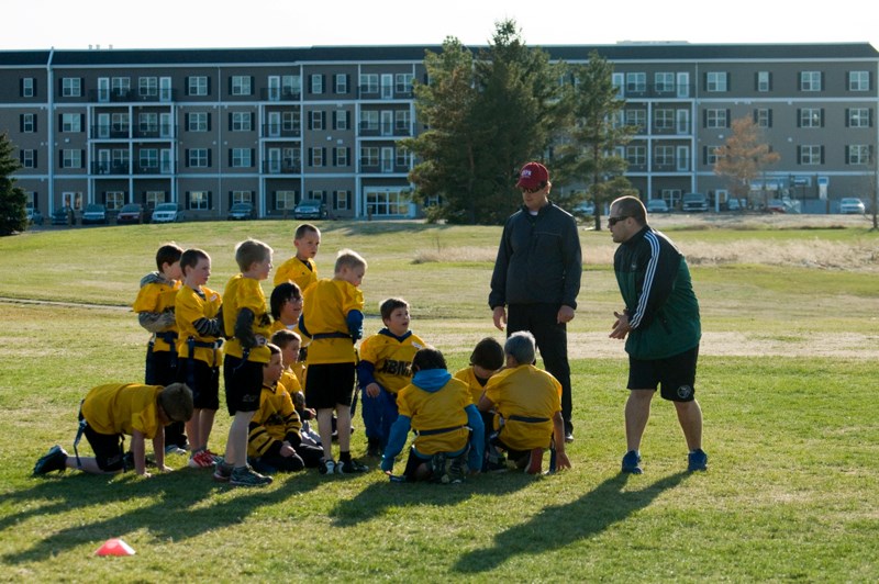 BMF president and coach Mike Humenny gives instructions to a flag football team. The flag football division is made up of players from Grades 3 and 4.