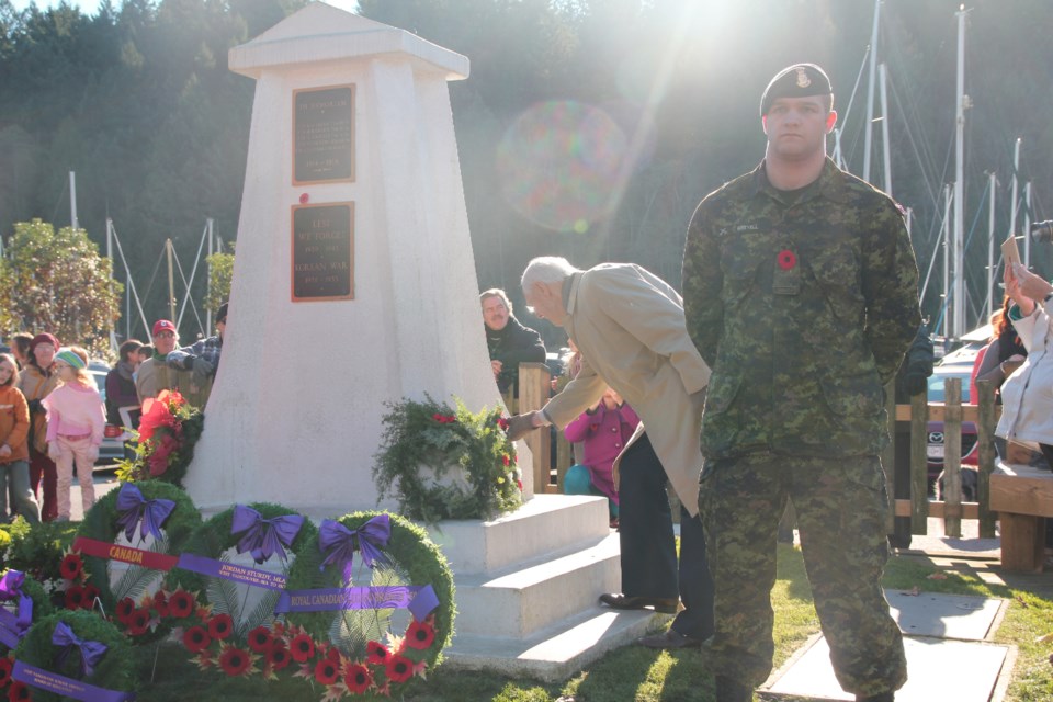 Frank Neilsen, a former member of the Danish Resistance lays a wreath. Marty Greyell, a reservist with The Seaforth Highlanders of Canada, stands in front of him.