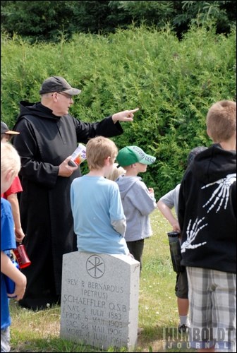 Father Demetrius Wasylyniuk, OSB, points out an interesting grave to the children of the City of Humboldt&#8217;s Kids Summer Fun Program during a field trip to St. Peter&#8217;s Abbey and College on July 8.