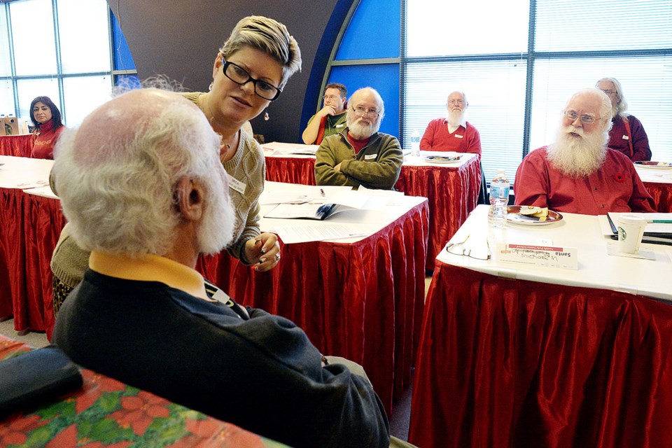 A rosy glow: Erica Beckstead of The Makeup Squad demonstrates techniques for getting rosy cheeks on Santa Richard. The Santas return to school each fall to fine-tune their skills for the holidays.