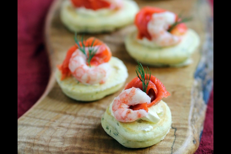 This deluxe appetizer is made by topping tender, savoury and easy-to-make little pancakes with vreme fraiche, smoked salmon, shrimp and dill.