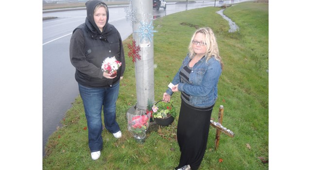 Christy Mahy’s friends, Stacey Charron, left, and Brandie Mol, replenish the makeshift memorial on Monday.