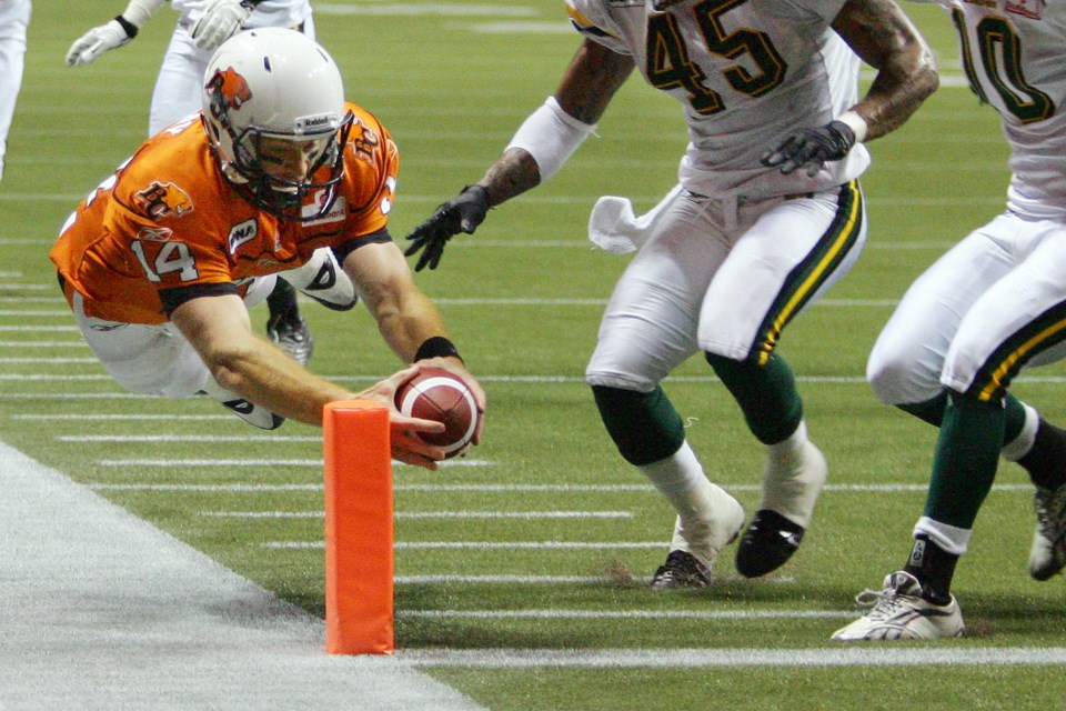 In a 2011 regular season game at B.C. Place -- the first with the retractable roof -- Lions quarterback Travis Lulay dives to squeeze the ball into the end zone. The Lions would go on the win the Grey Cup at home. Photo Kevin Hill