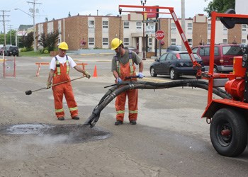 Workers demonstrate the Dura-Patch pothole system, which the City of Yorkton is currently considering purchasing. The new system would mean lower operating costs and a longer life for the repaired areas.