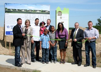 A partnership between the City of Yorkton, the Government of Saskatchewan, and the Credit Union is helping to bring more affordable homes to the city. On Friday ribbons were cut at two new locations that will see the development of 20 entry-level homes in Yorkton. Pictured above (l-r) are Kevin Lukey, Cornerstone Credit Union; Wanda Hunchak, VP Westcap Mgt.;  Ryan Bent, children and wife Lisa (purchasers of one of the homes to be constructed, through the assistance of the HeadStart Program); Mayor James Wilson (standing with the Bent family); MLA Greg Ottenbreit; and Lee Rusnak, Deneschuk Homes, building contractor for the above housing project.