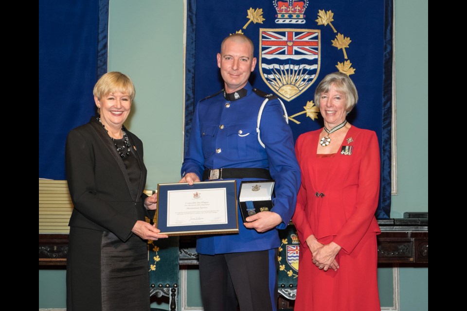 Merit: Const. Stu Hagen, centre, is presented with the Award of Meritorious Service from Suzanne Anton, attorney general and minister of justice, left, and Lt. Gov. Judith Guichon, right.