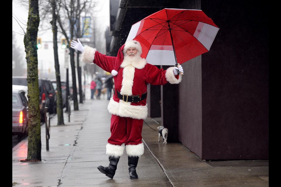 Santa braved the rain on Saturday to greet shoppers along Hastings Street during the annual Light up the Heights event.