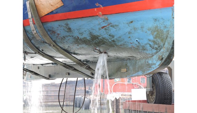 Water gushes from the hull of the Steveston Lifeboat as it's raised to dry dock at New Westminster