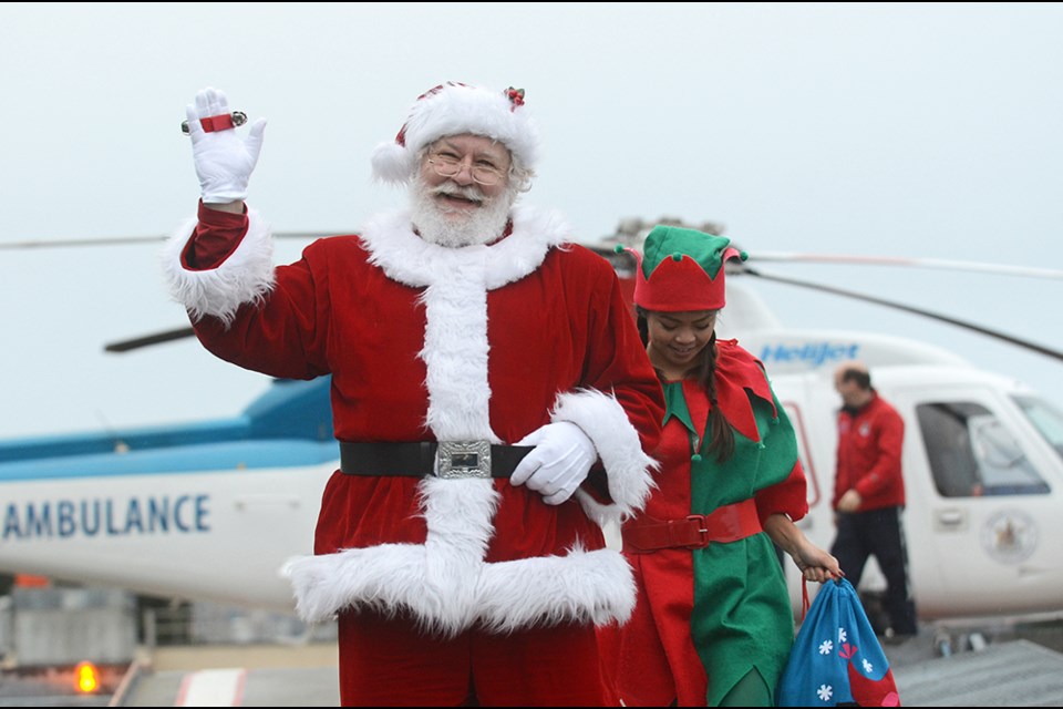 Santa and elf Gizelle Manese arrive at Royal Columbian Hospital Tuesday for an early toy run.