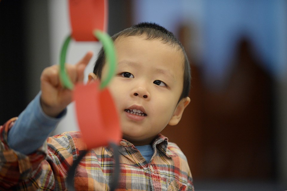 Getting crafty: Four-year-old Eason Wong made a Kwanzaa paper chain at Anvil Centre. Crafts, cookie decorating and entertainments were among the post-parade offerings at Anvil Centre.