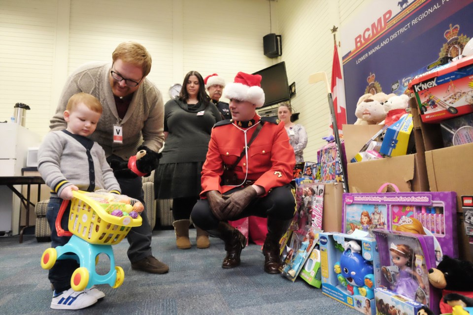 In Keian’s name: Ryan Blundell and two-year-old son Ryan, with Const. Sam Bowen, check out some of the toys donated by Mounties for Keian’s Holiday Wish Toy Drive.