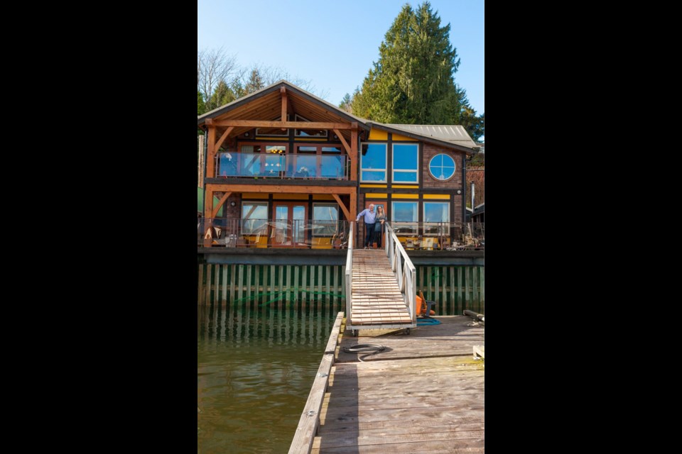 Owners Peter Fitzpatrick and Cheryle Henry enjoy their stilt home, which features generous windows, massive beams over the two decks and a gangway to their private dock.