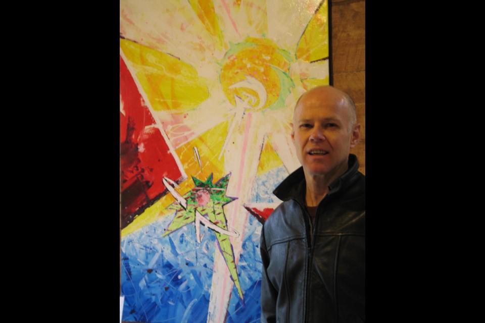 One of the 90 entries in the annual Friends of the Gallery show, Kodrum Evets (aka Steve Murdok) poses in front of his acrylic Luxenesis.