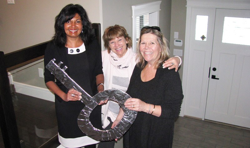 Sandra DaSilva, left, winner of the Dream Home Lottery, takes a peek at her new home with Prince George Hospice Society board member Marija Soklic, centre, and executive director, Donna Flood.