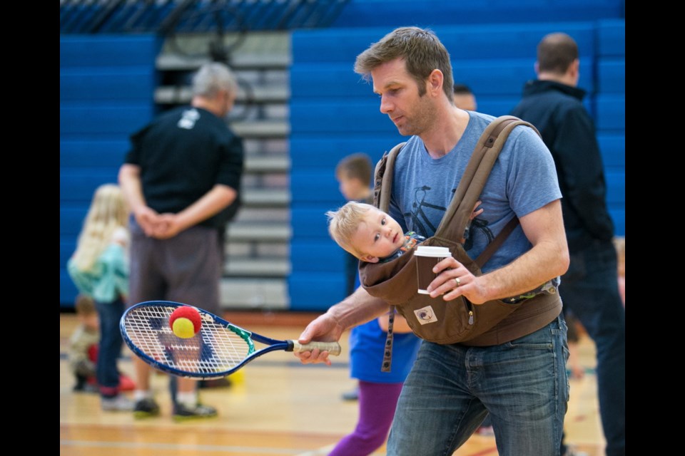Monday: Nathaniel Stoffelsma plays tennis with his son seven-month-old Jens Stoffelsma during Physical Literacy Family Day at the Pacific Institute for Sport Excellence.