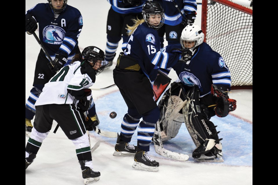 PEI forward Sami Sentner, NWT Bryn Hill and NWT goalie Ayesha Barlas all keep their eye on the puck during a game Wednesday at CN Centre during the Canada Winter Games.